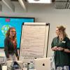 Two researchers, presenting from a flip chart